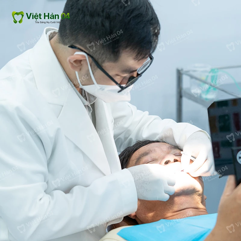 Bác sĩ kiểm tra độ ổn định của trụ và vệ sinh răng miệng chuyên sâu